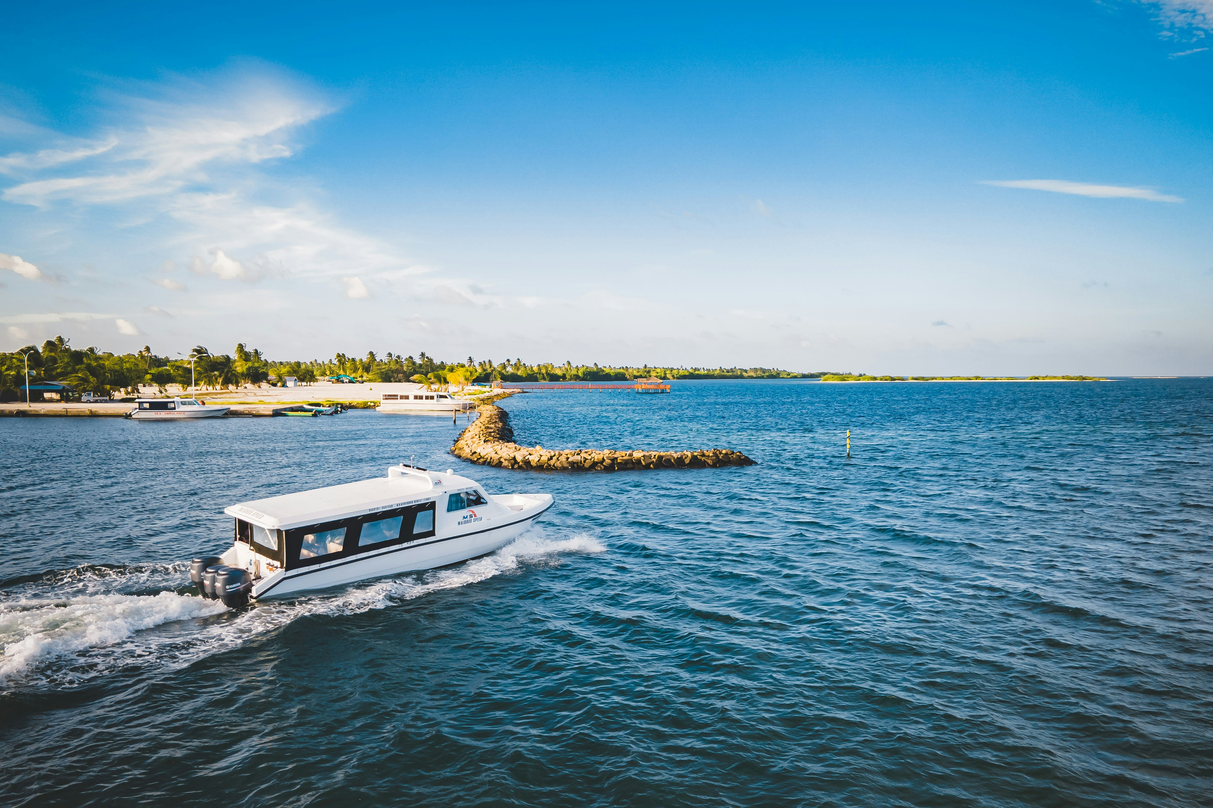 A speedboat cruises along the blue waters.