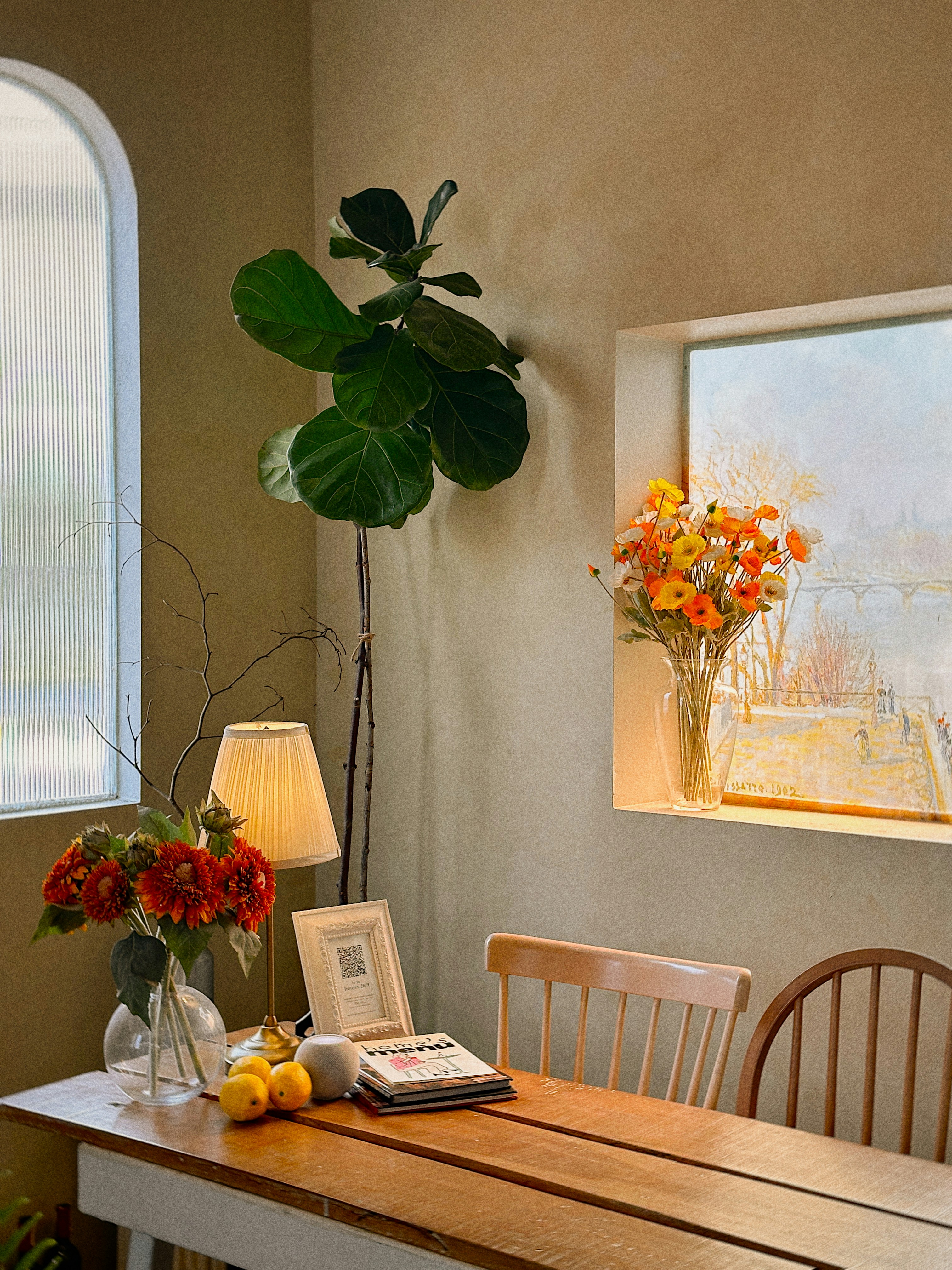 Gemütlicher, lichtdurchfluteter Raum mit Blumen und einer Pflanze.