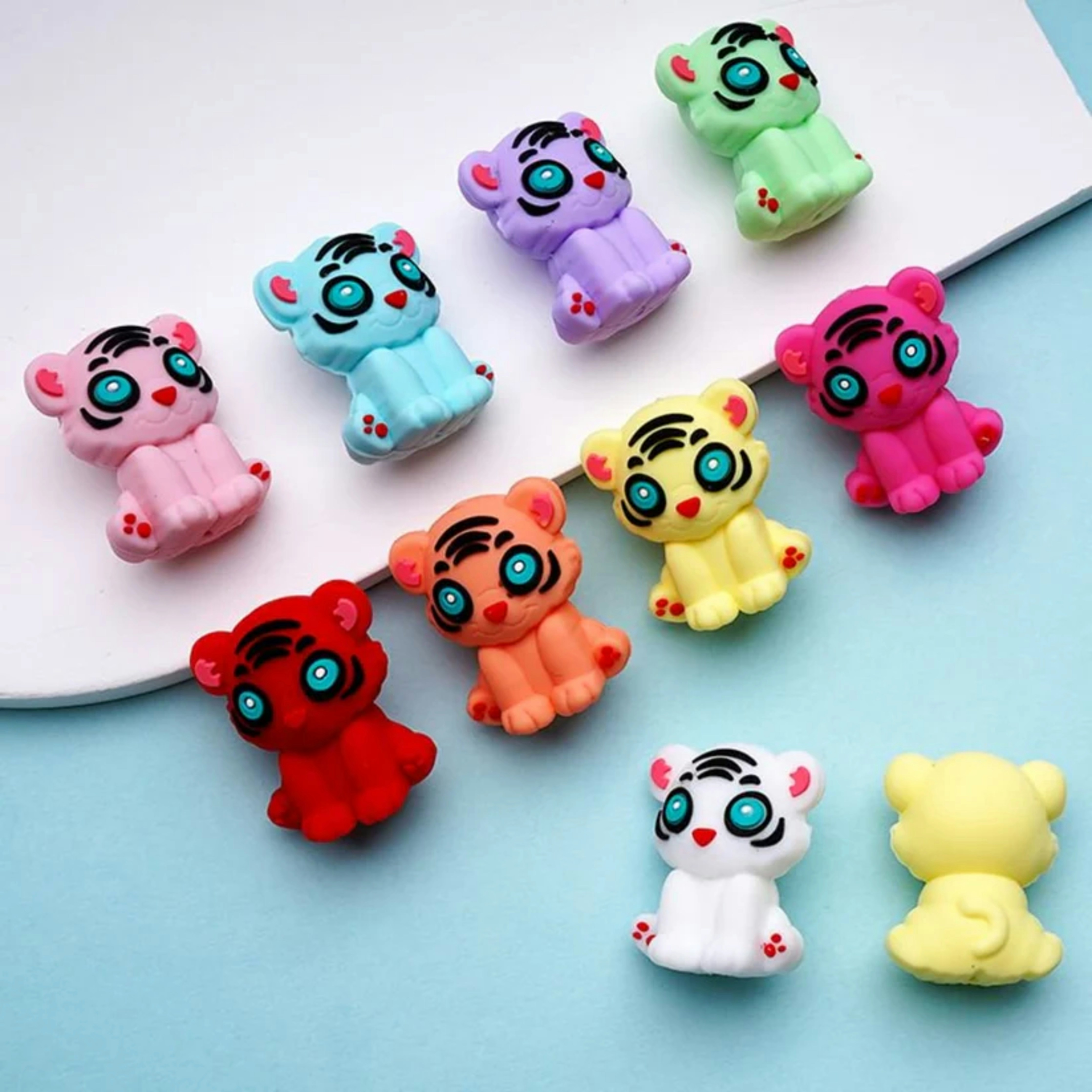 Colorful tiger figurines in various shades are arranged.