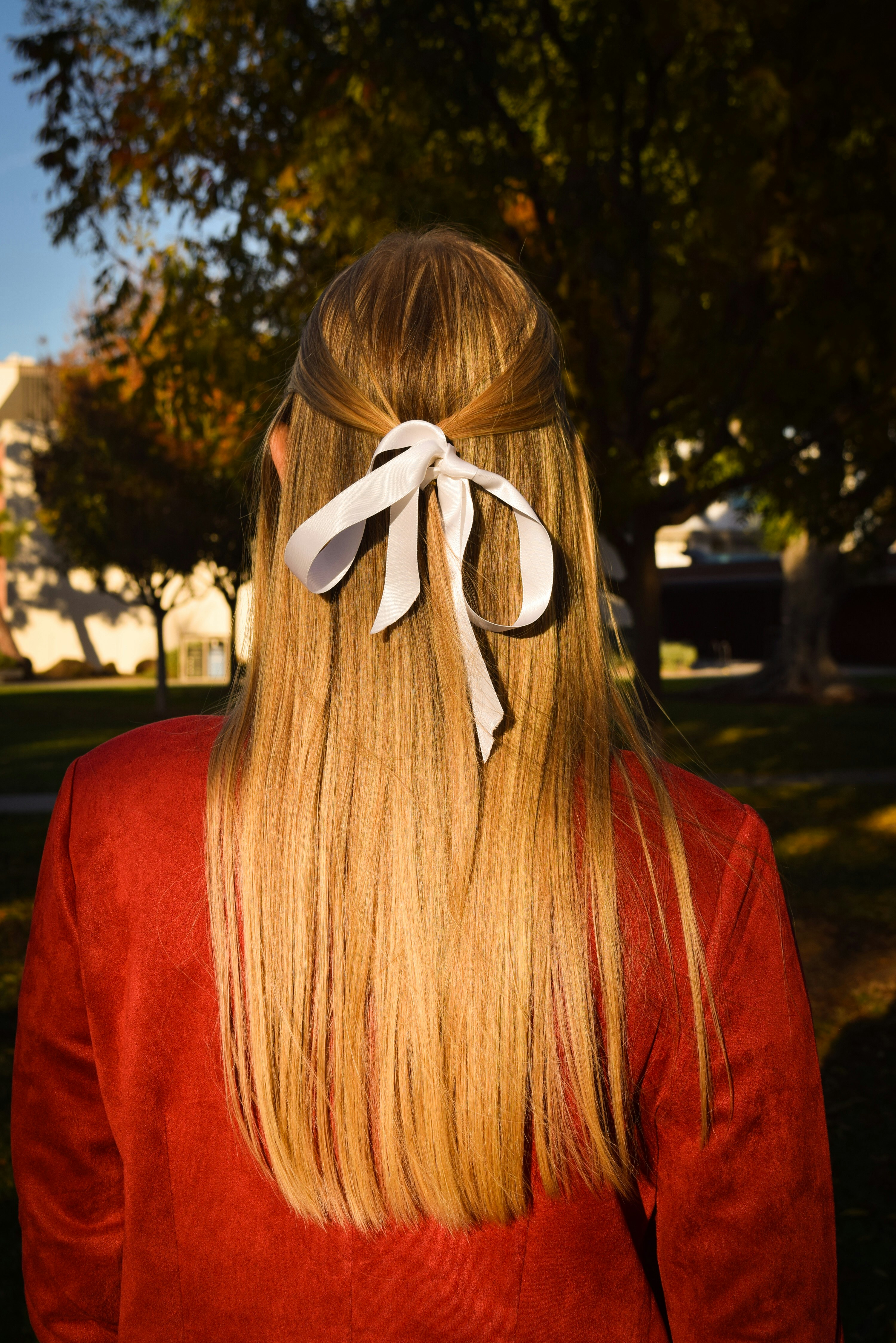 Capelli biondi da donna con fiocco bianco.