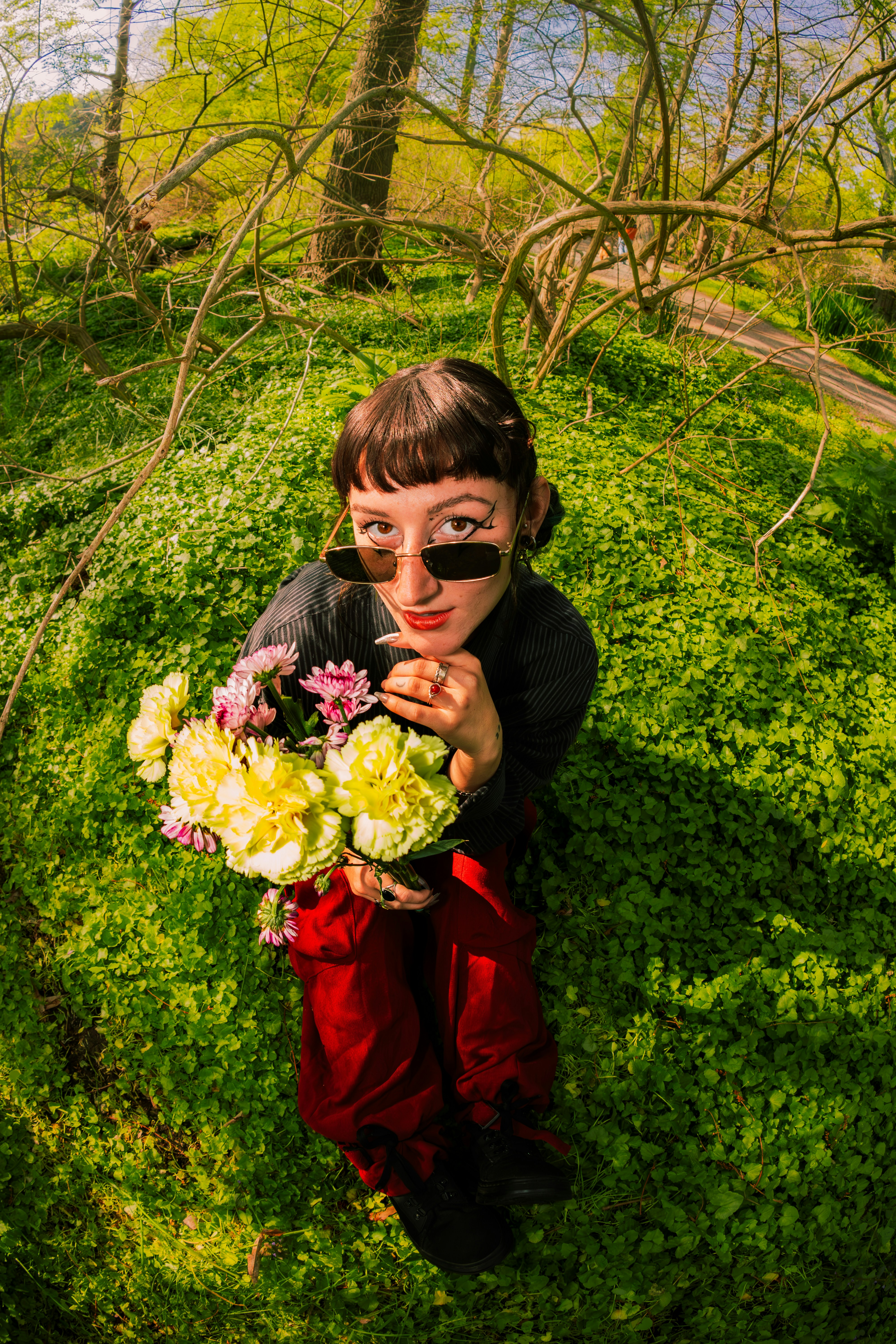 Wanita di padang rumput memegang buket bunga.
