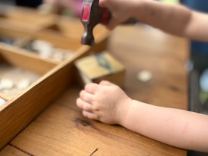 A child is hammering something on a table.