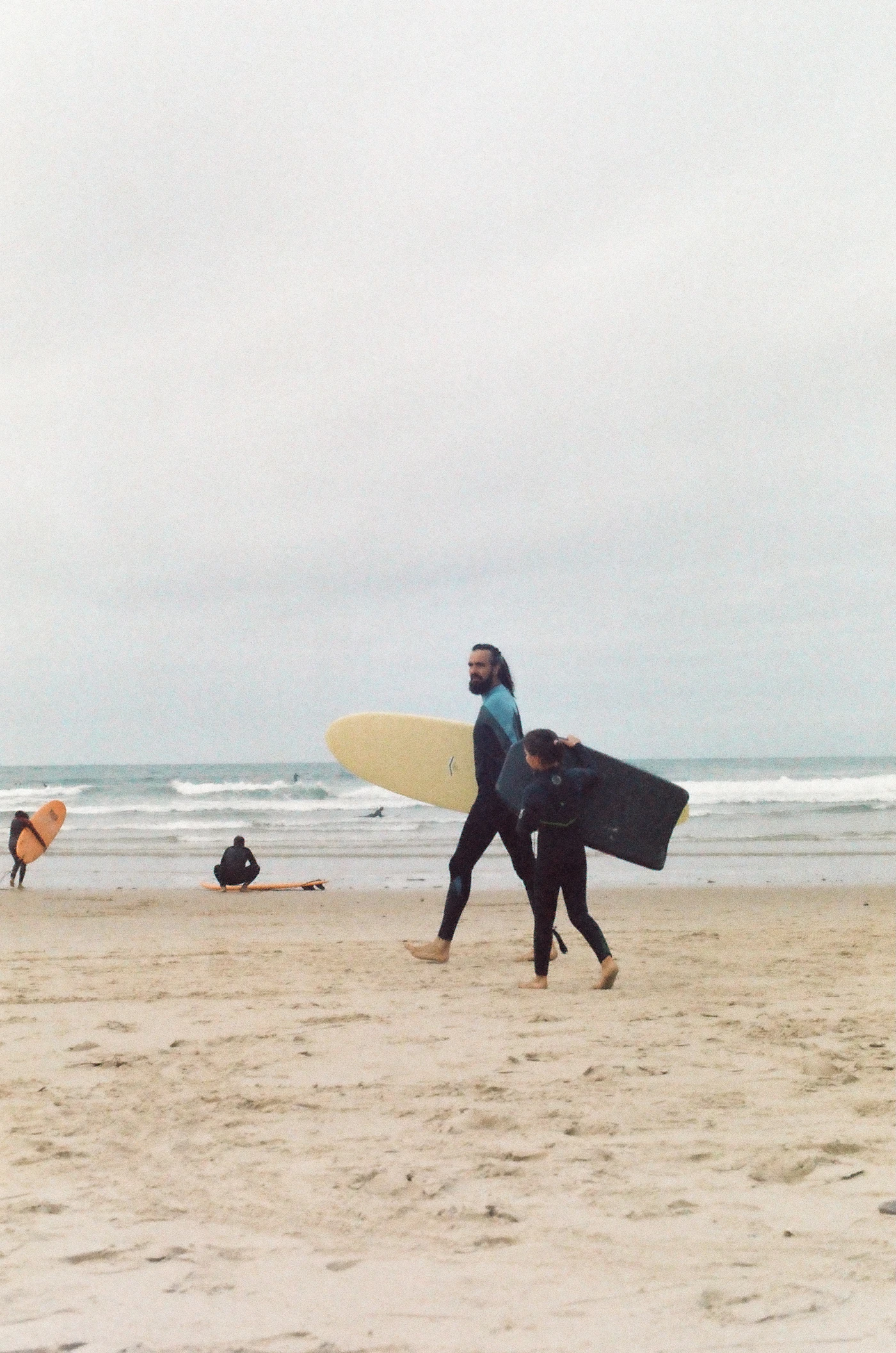 Surfers walking on the beach with boards in Baleal, Portugal