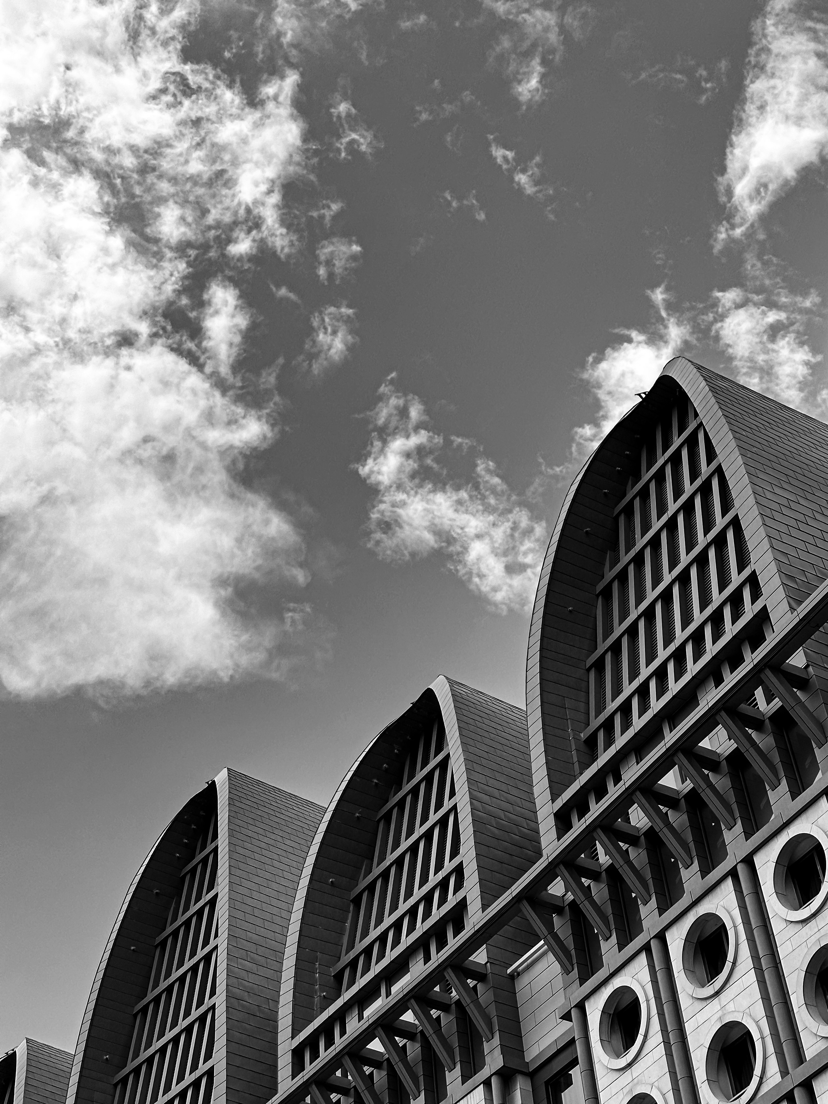 Buildings with arched windows reach toward the cloudy sky.