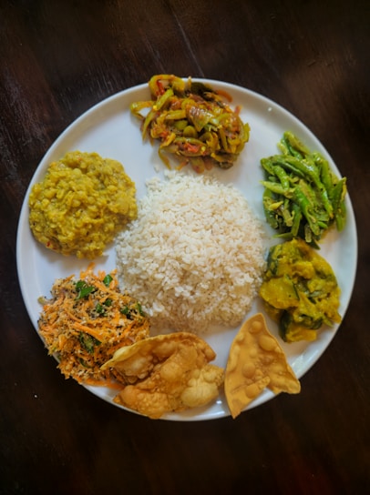 A plate of rice and various south asian dishes.