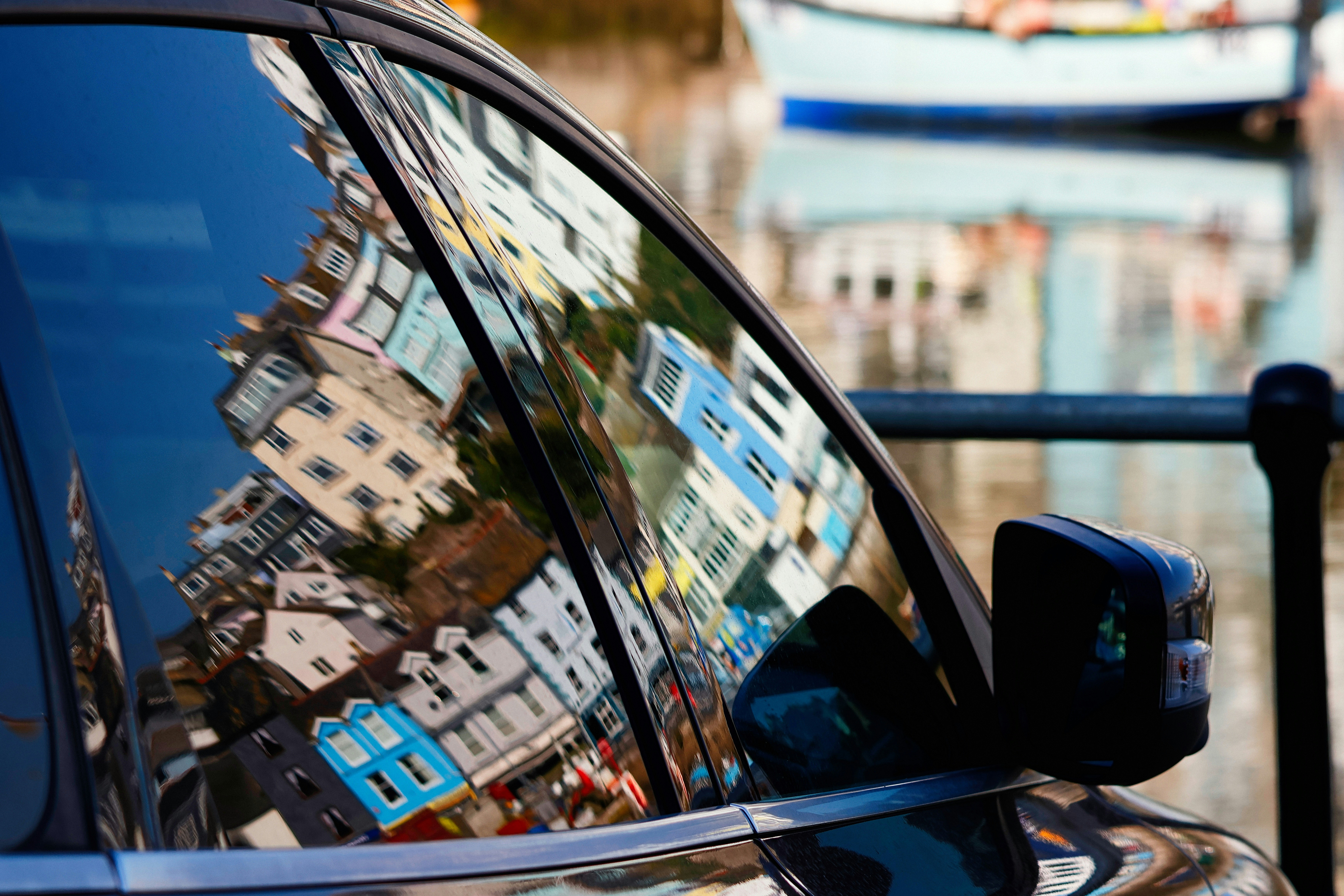 The car window reflects colorful buildings.