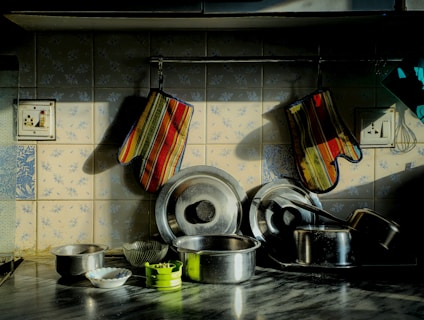 Kitchen pots and pans with oven mitts.