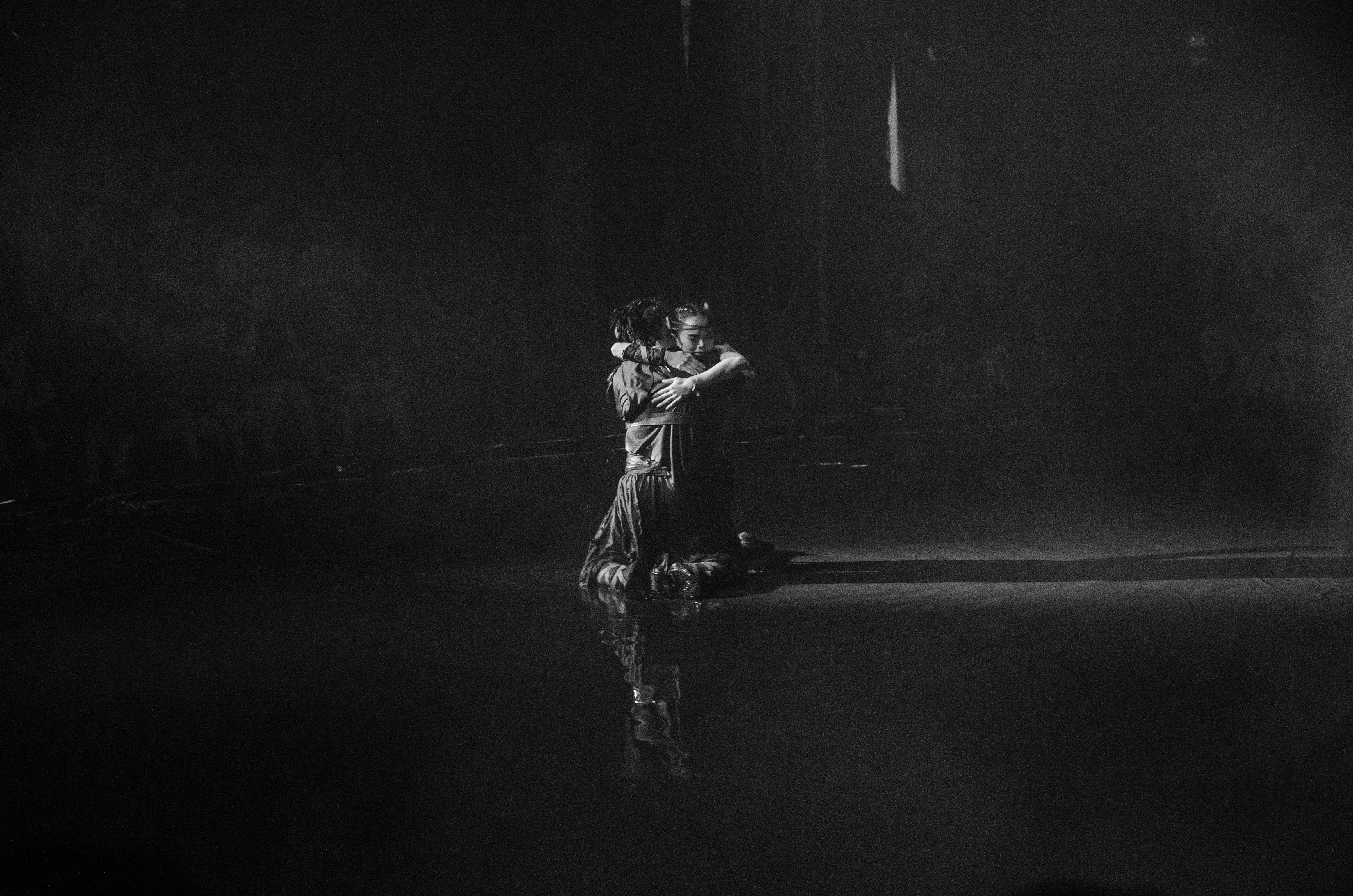A couple dances gracefully in the spotlight.