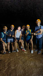 Group of people posing in a dark cave