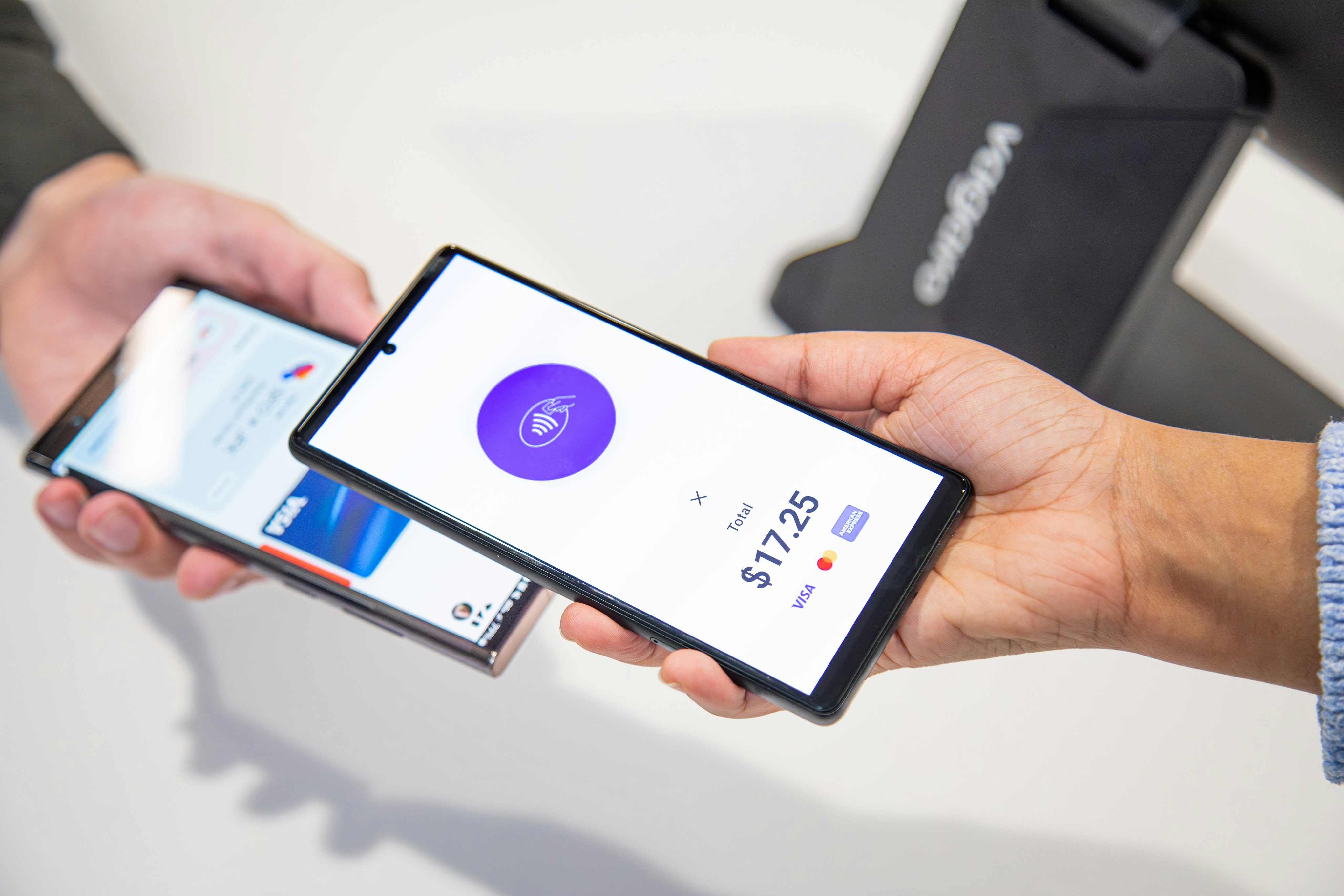 person holding Android smartphone transferring file wirelessly to tablet