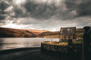 A moody landscape with an old stone house.