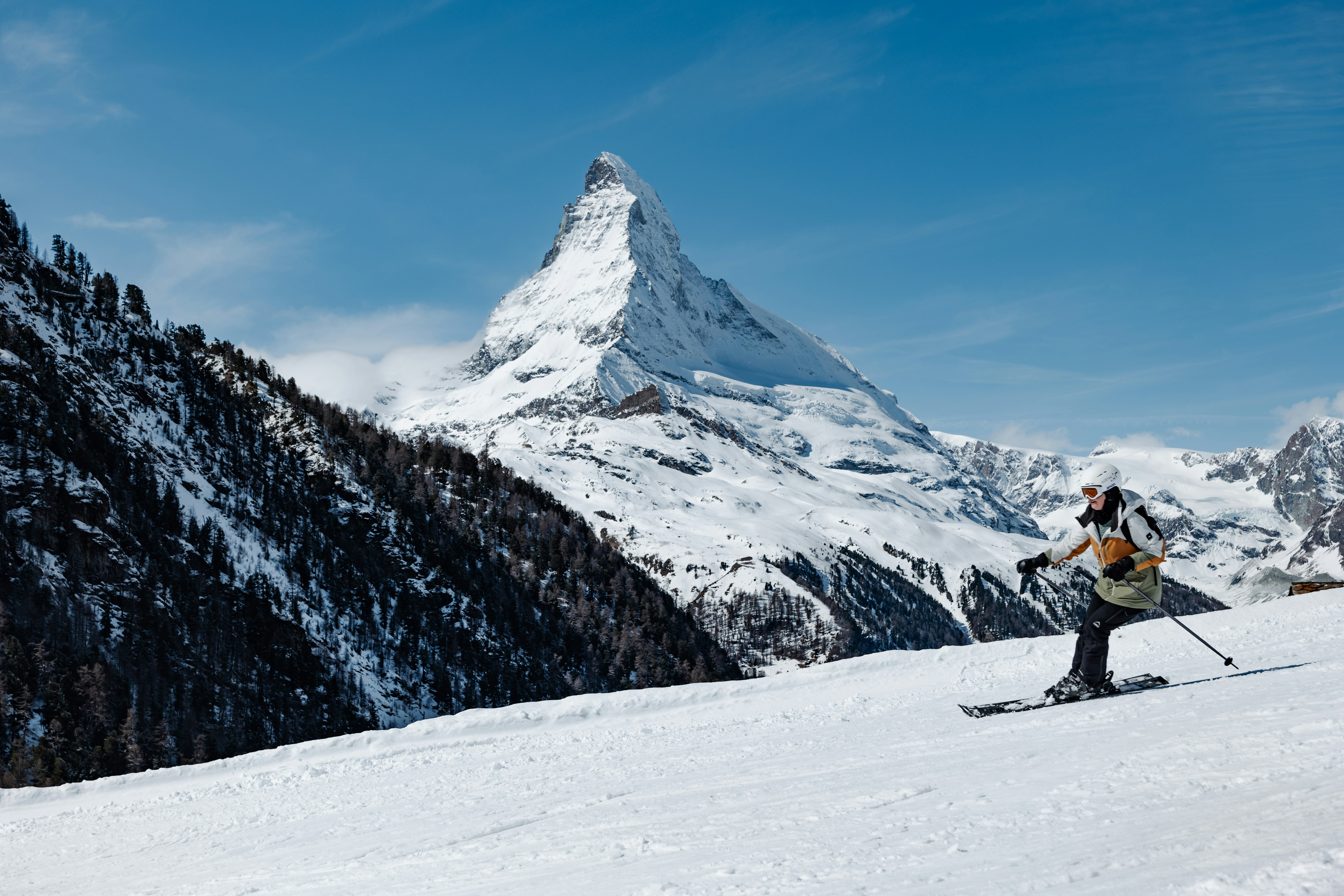 Skier enjoys a sunny day with matterhorn view.