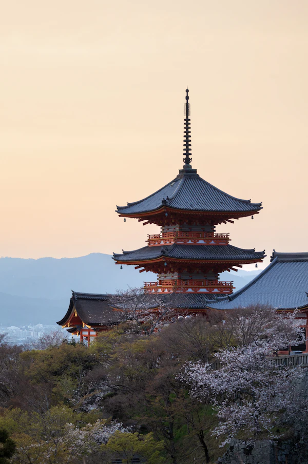 A Kyoto pagoda silhouetted against a warm evening sky.