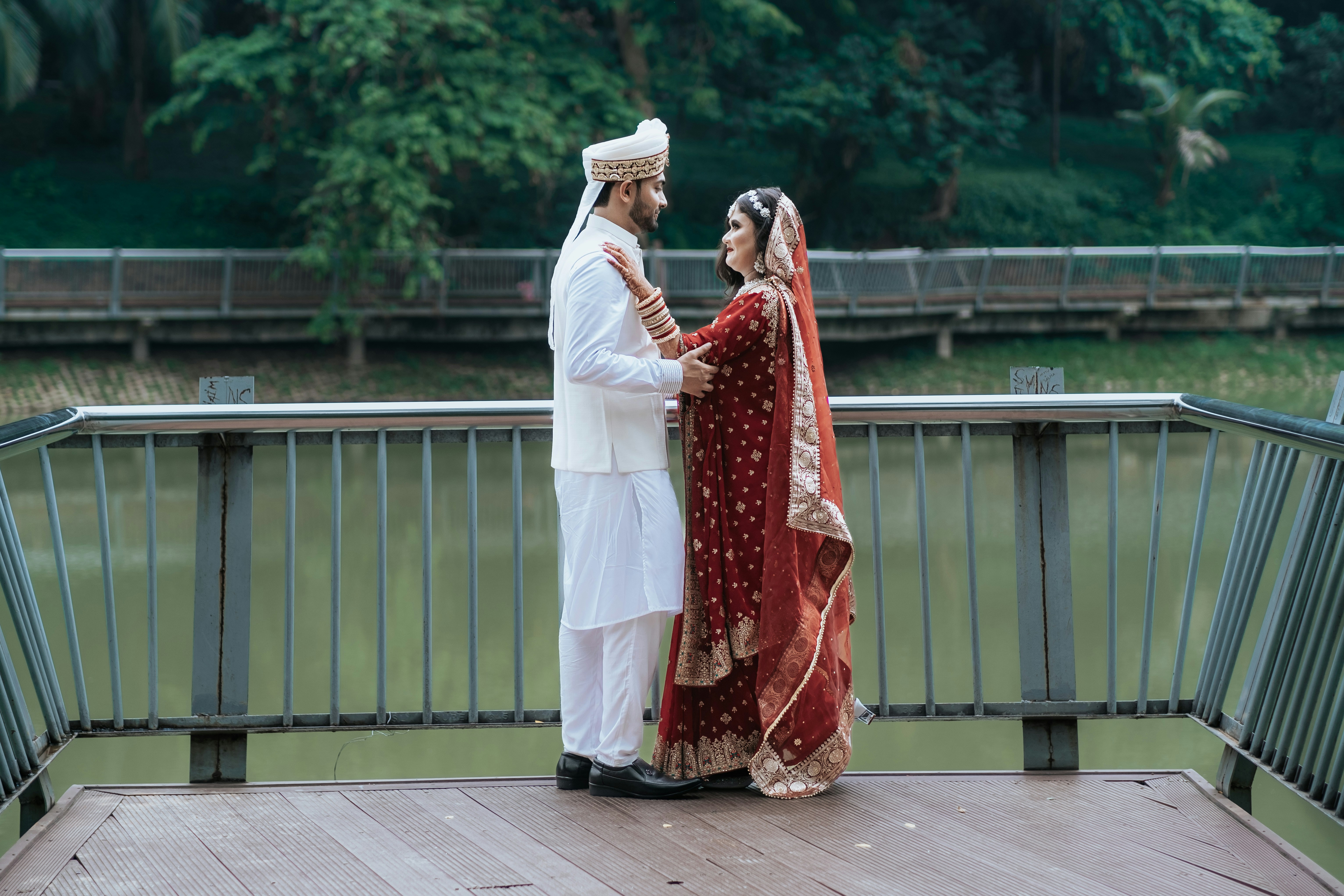 Newlyweds pose together in traditional wedding attire.