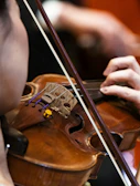 A person plays a violin during a performance.