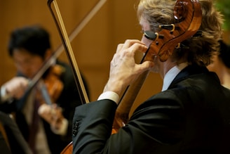 An orchestra plays musical instruments in concert.