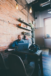Man works on a laptop in a cozy cafe.