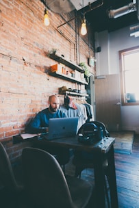 Man works on a laptop in a cozy cafe.