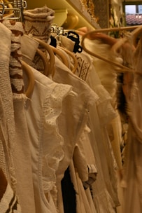 White clothing hangs on a clothing rack.