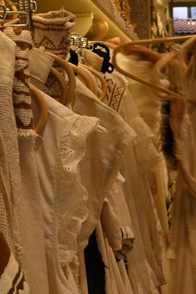 White clothing hangs on a clothing rack.