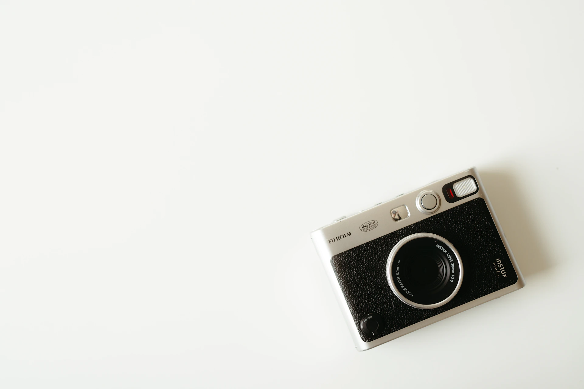 A vintage camera sits on a white surface
