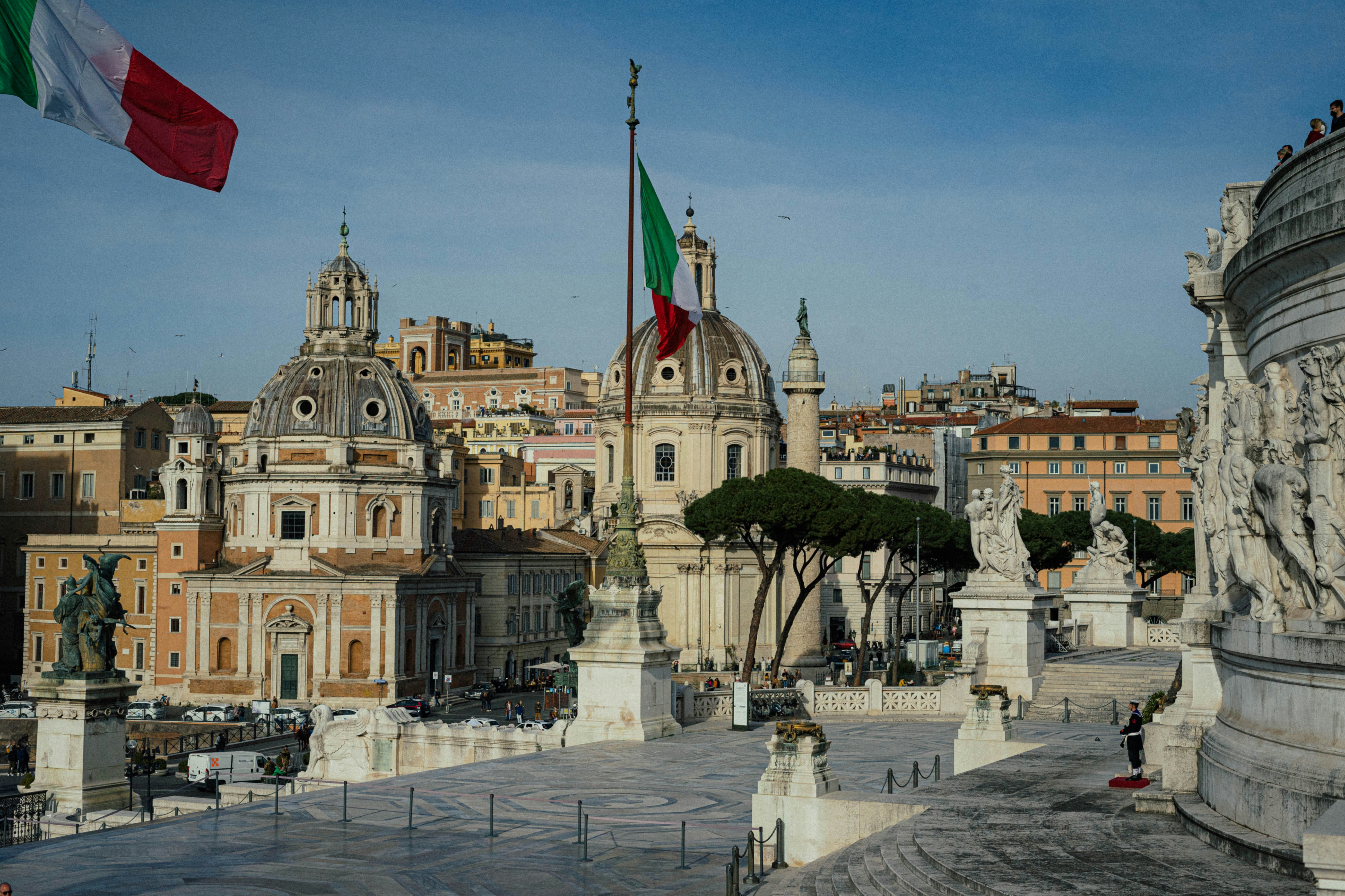 italian flag flies over rome's architecture.