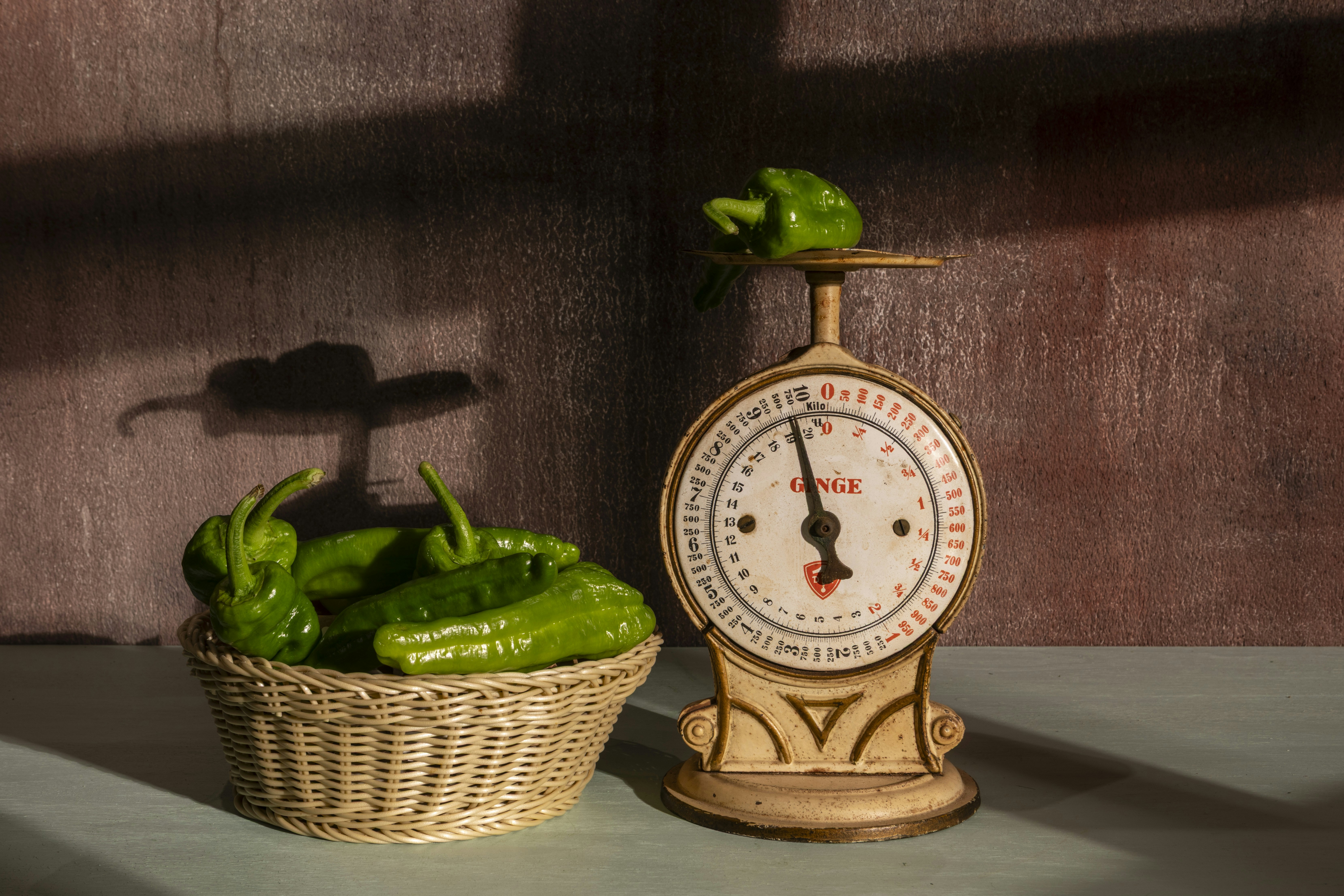 Green peppers are weighed on a vintage scale.