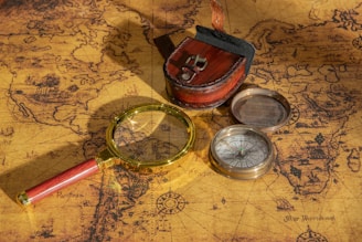 Magnifying glass and compass on an antique map.