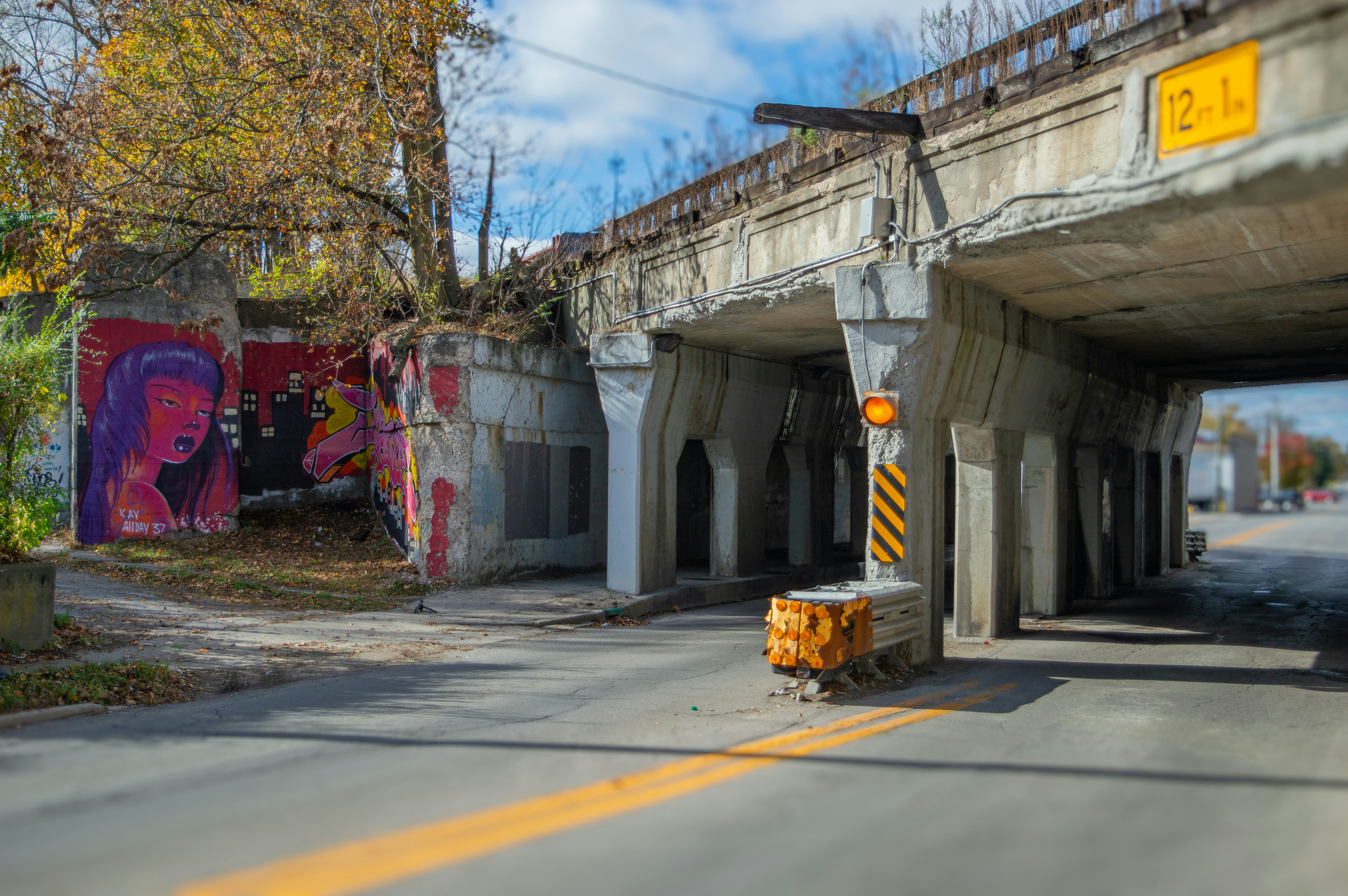 An underpass shows graffiti and concrete construction.