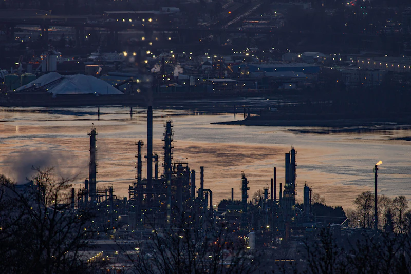 Oil refinery by the river at dusk
