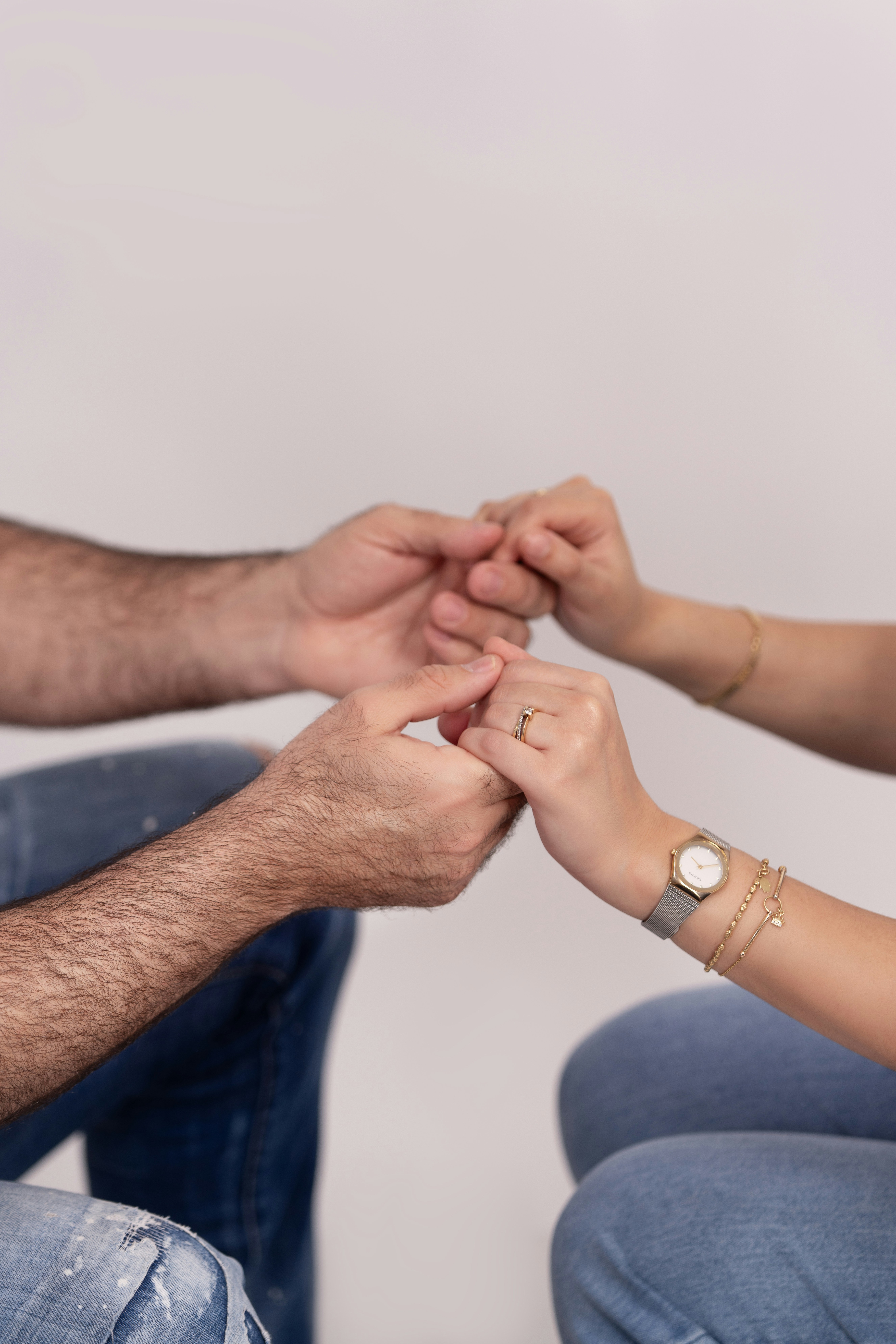 Two people hold hands, showing care.