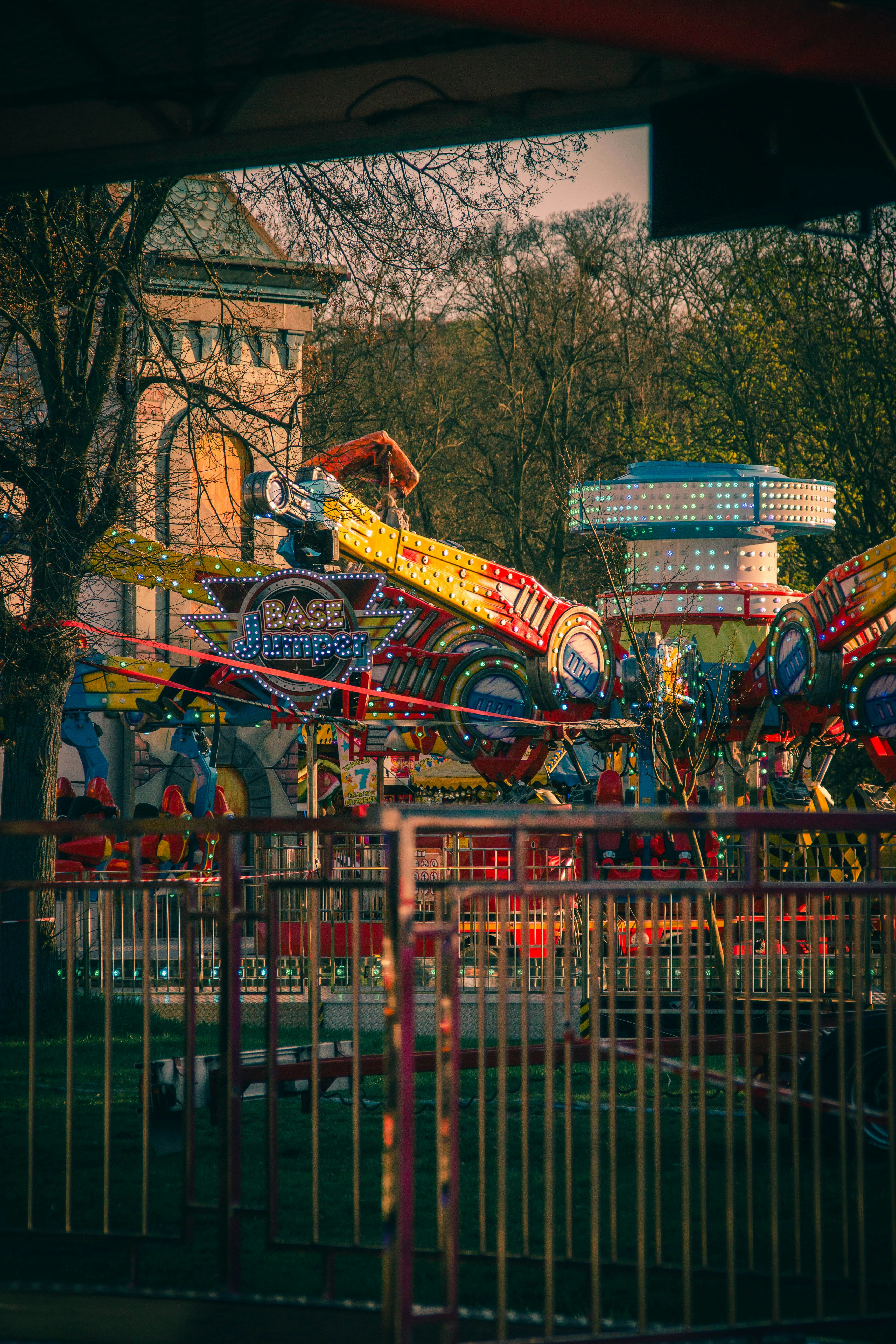 Carnival ride at dusk against a building.