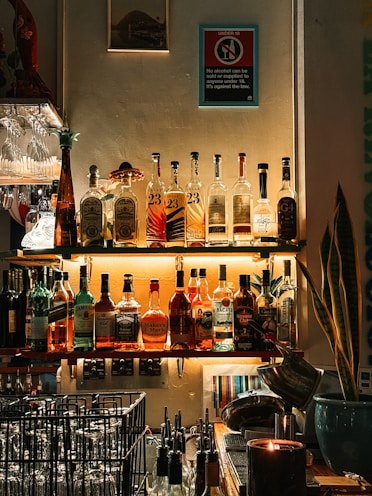 A well-stocked bar displays assorted liquor bottles.