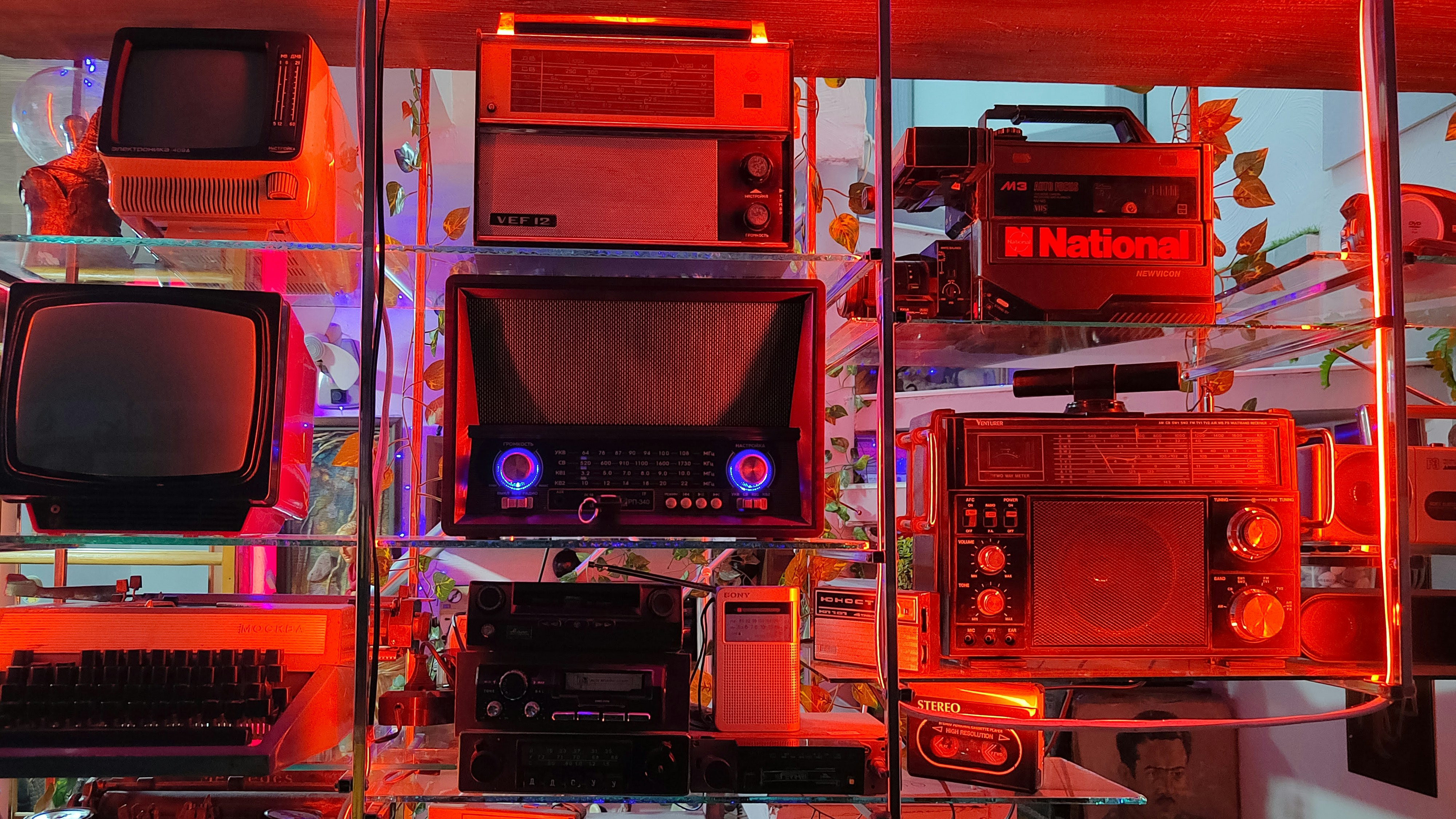 Vintage electronics are displayed on shelves with vibrant lighting.