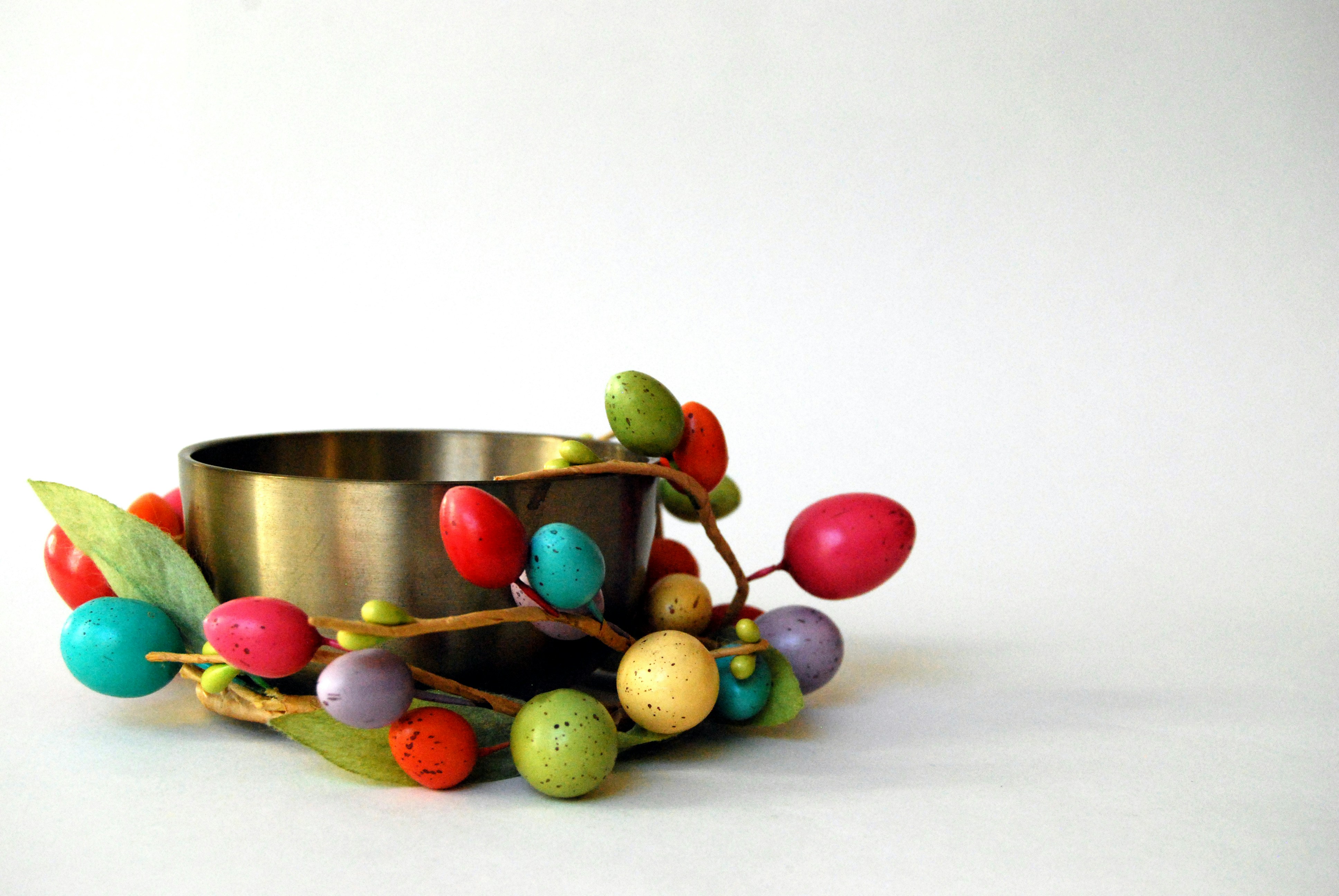 A candle holder decorated with colorful beads.