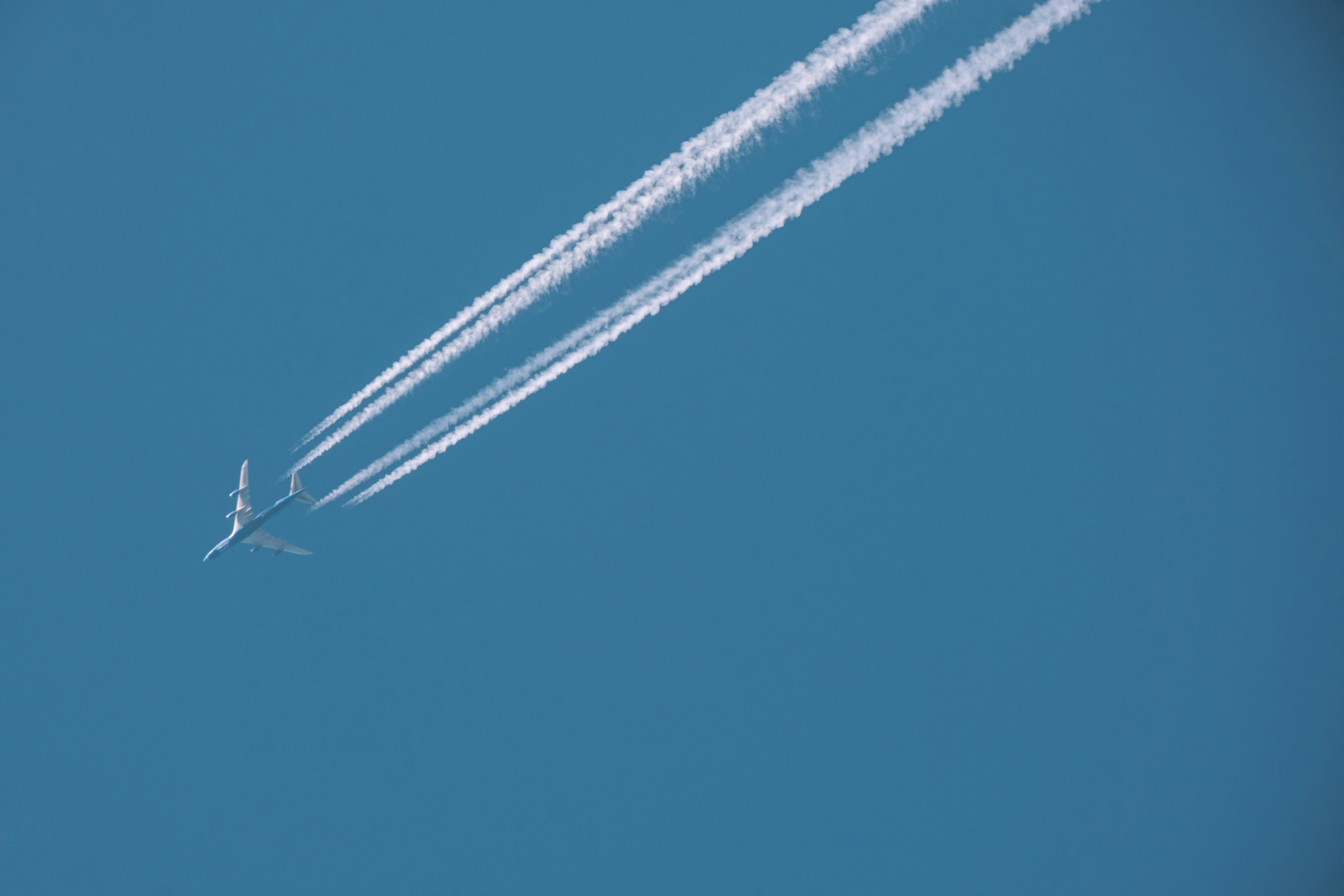 Airplane flying through the bright blue sky., 