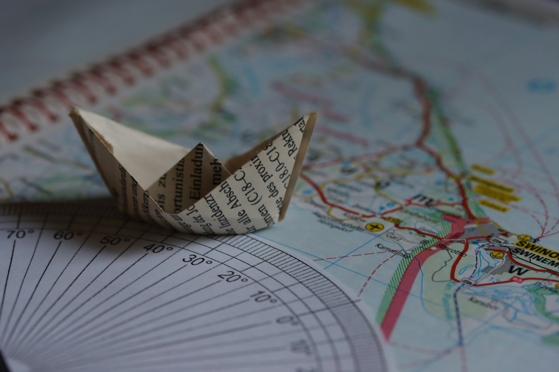 A paper boat sits on a map.