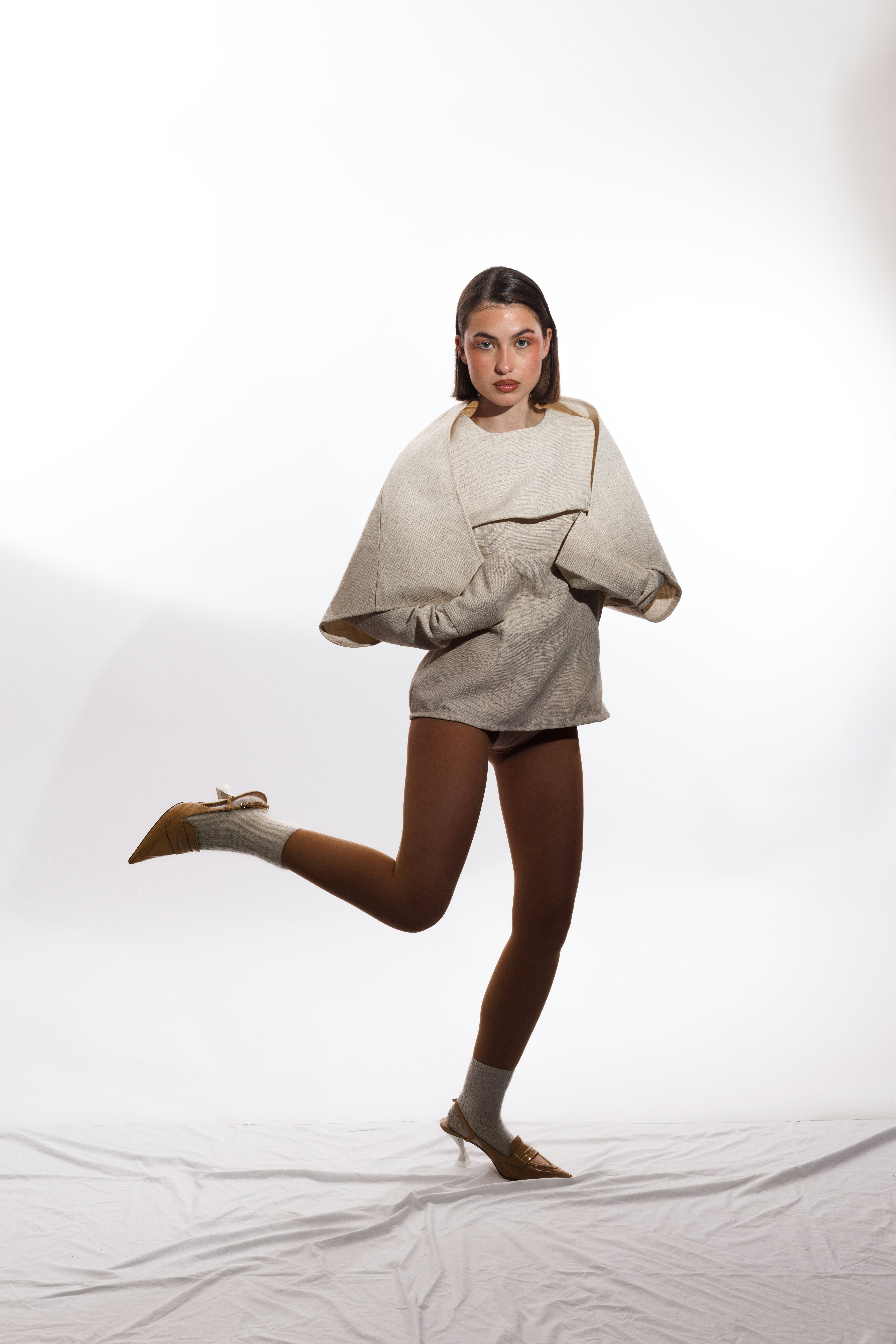 A woman in a stylish outfit strikes a pose.