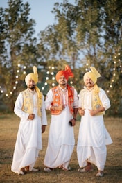 Three men pose in traditional punjabi attire.