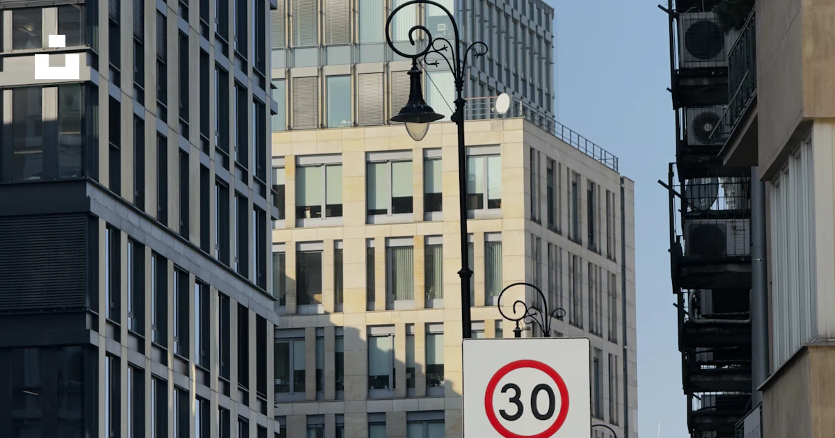 Speed Limit Building Buildings line a street with speed limit and traffic signs. photo ...