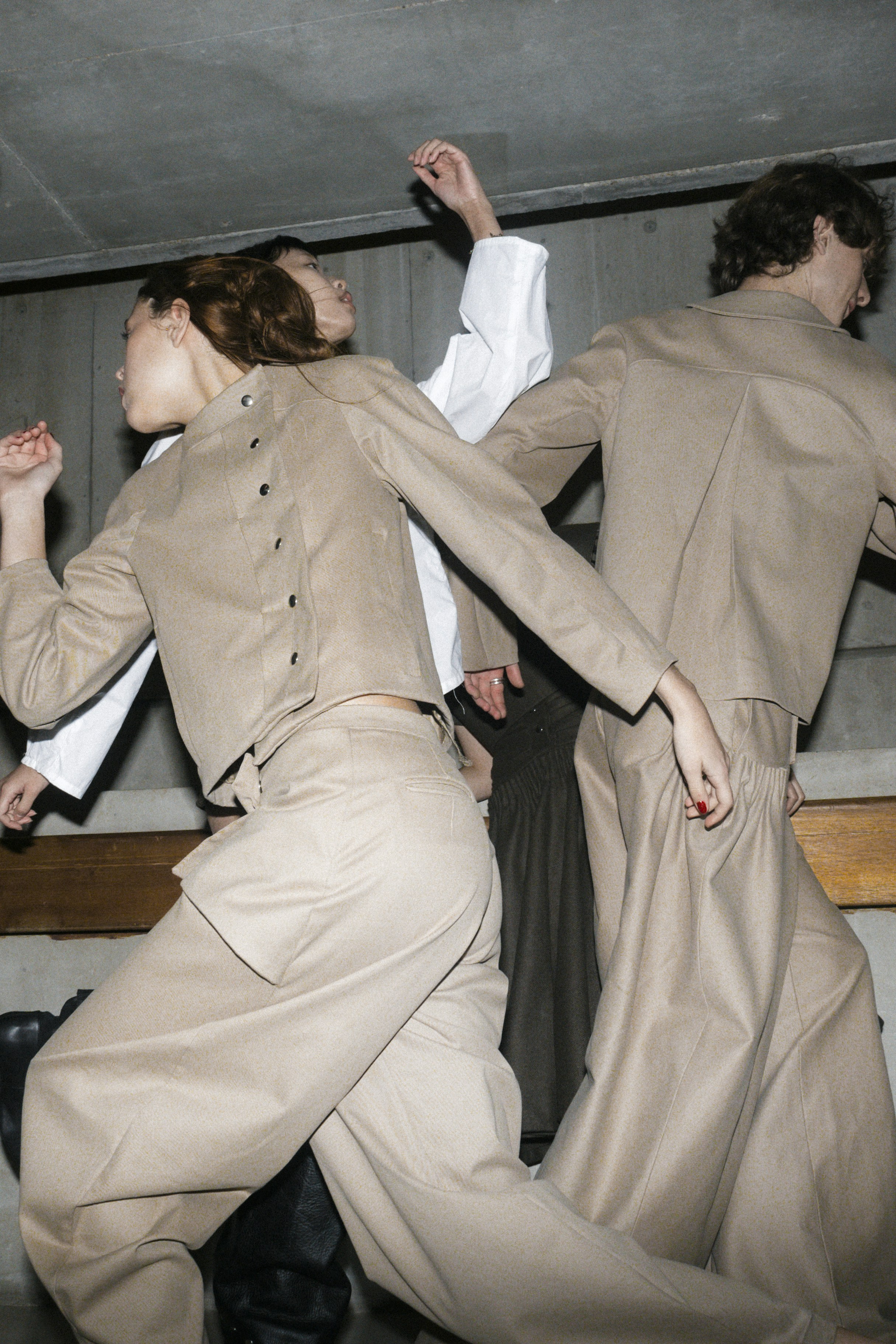 Models dance in a fashion show backstage.