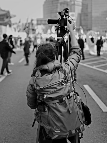 A person films on a city street.