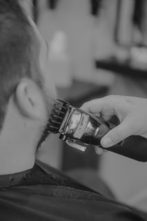 Someone is getting their beard trimmed with clippers.