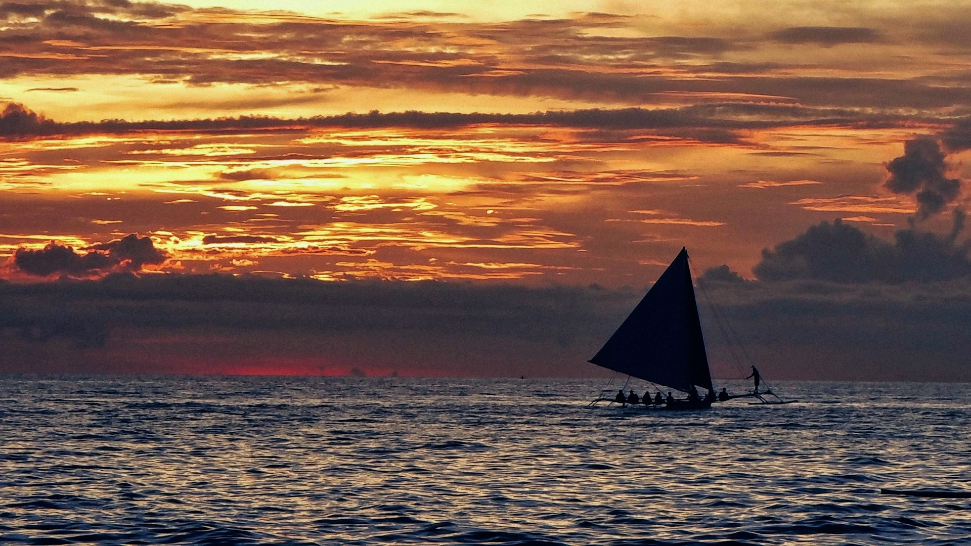 Sailboat silhouetted against a beautiful sunset.