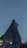 A woman wears a veil in front of the sky.