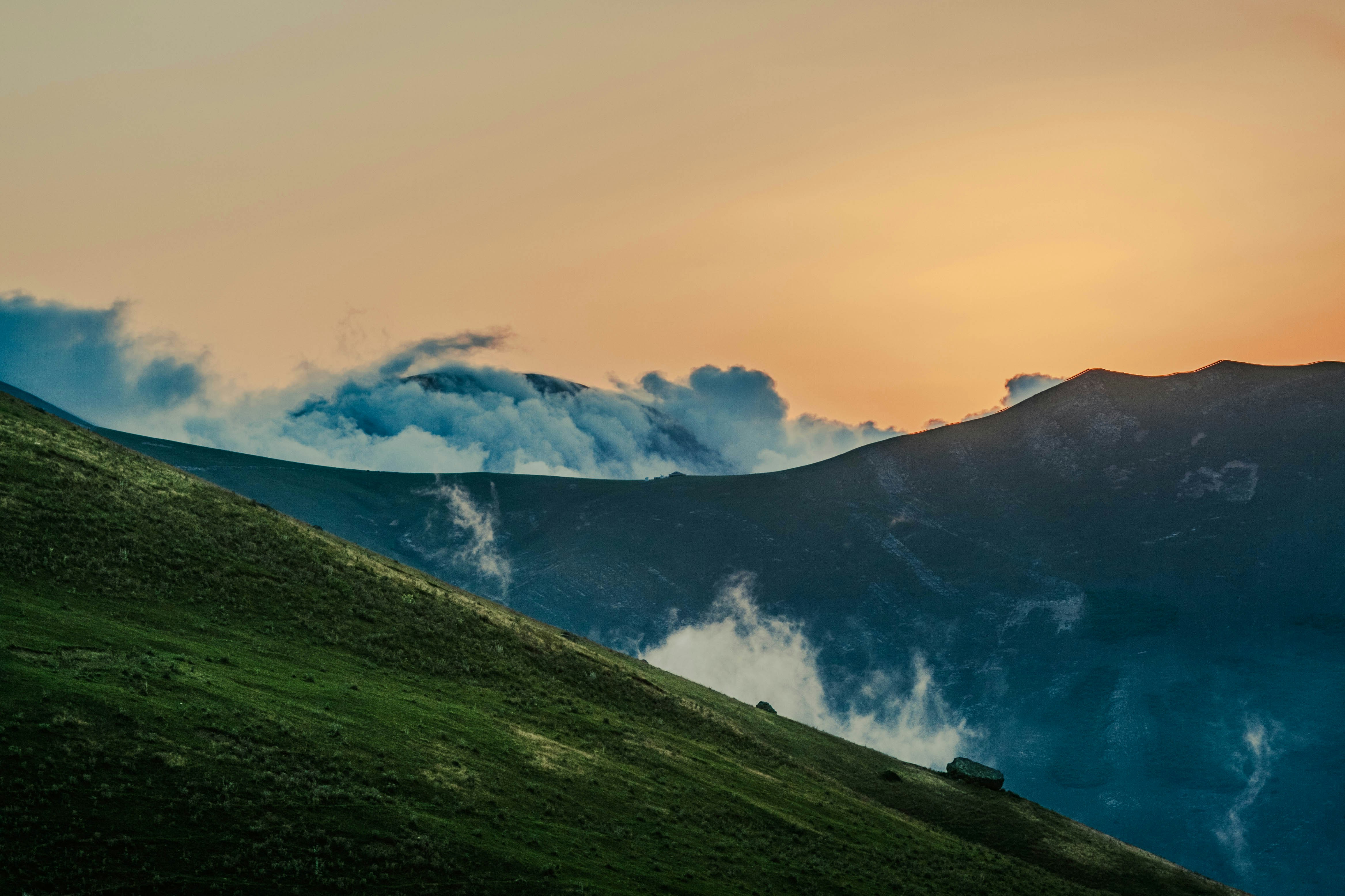 Mountains meet clouds at sunset.