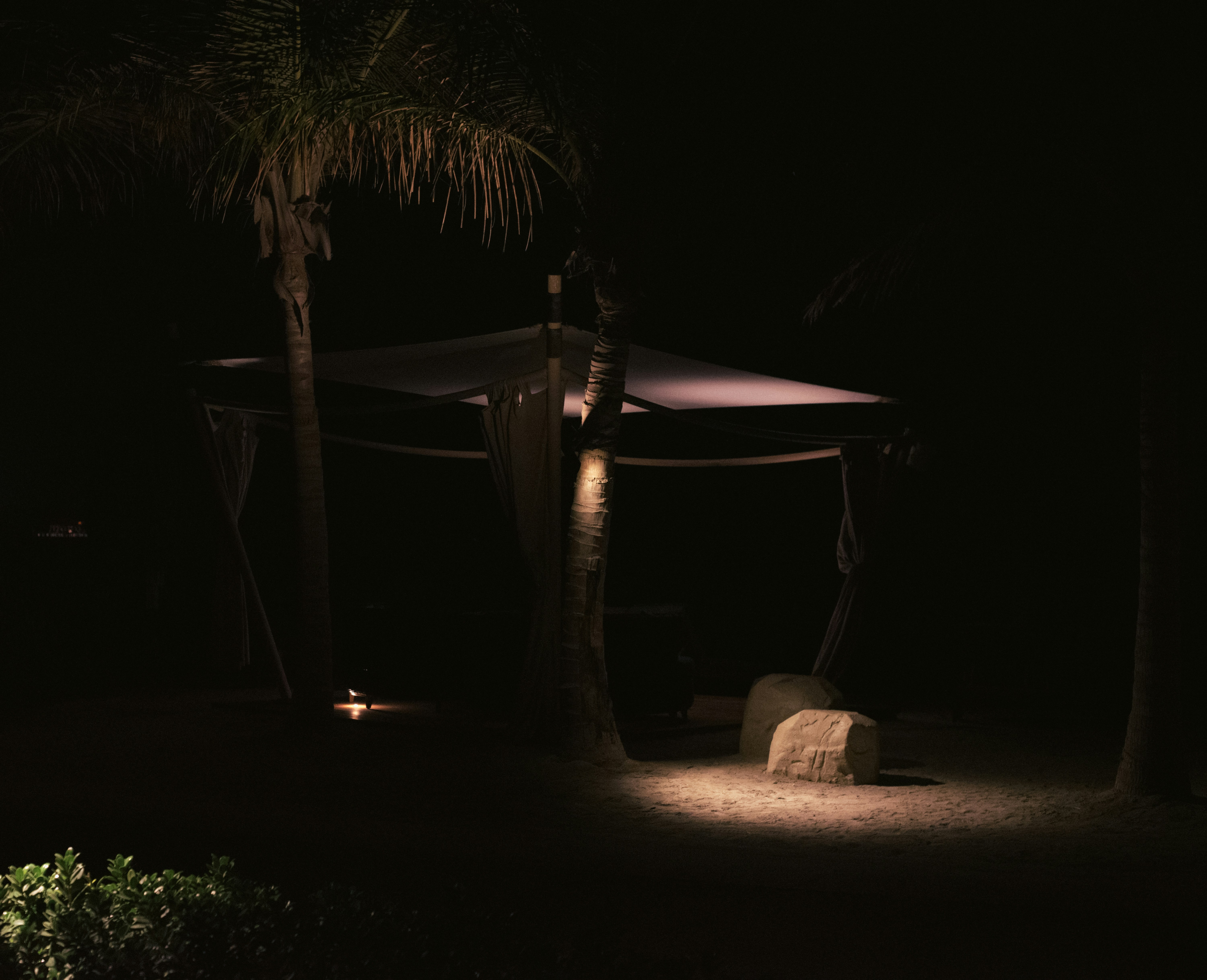 Nighttime outdoor gazebo with atmospheric lighting.