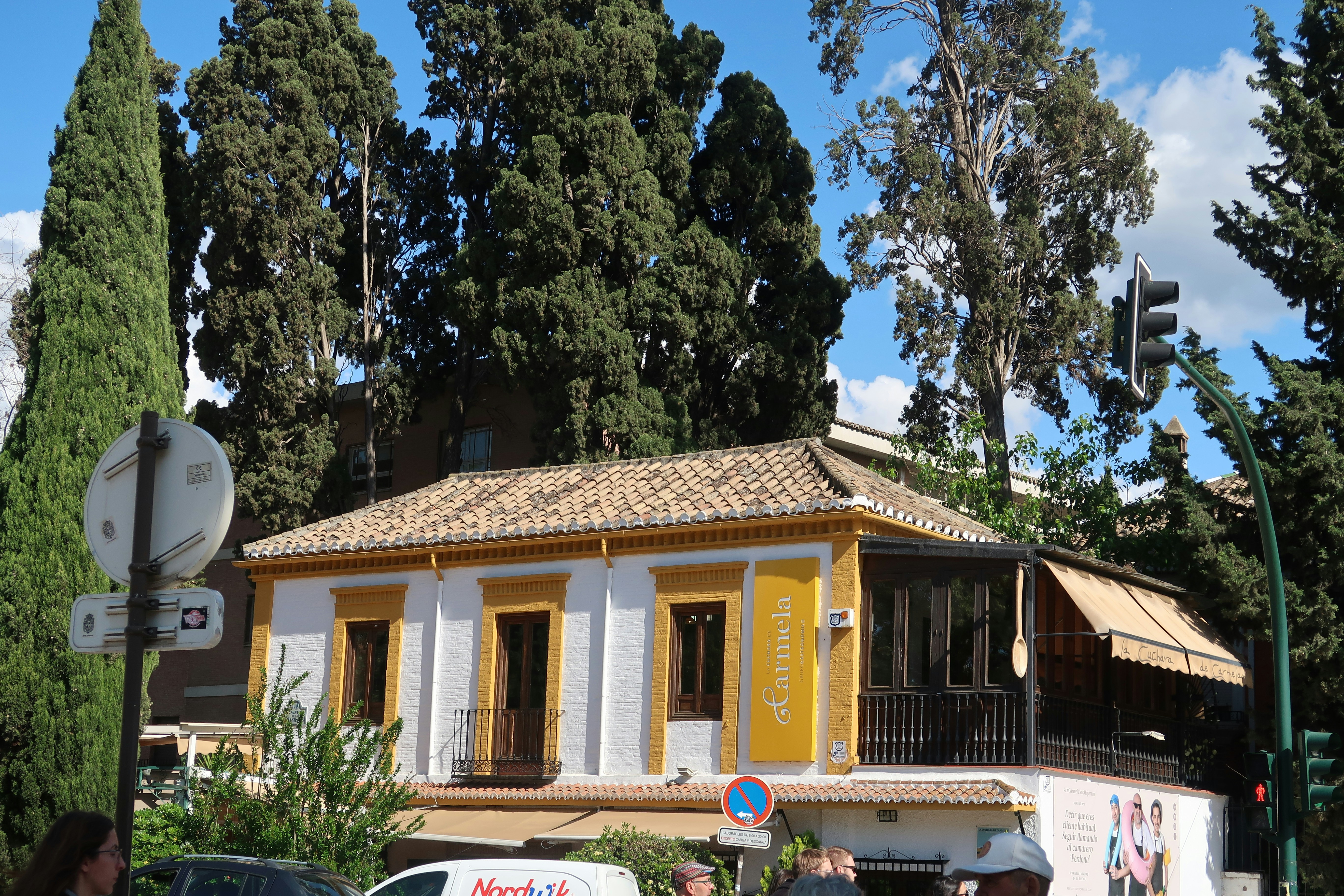 Small building with a yellow facade and trees.