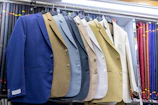 Several suits are on display in a shop.