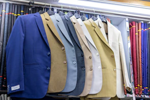 Several suits are on display in a shop.